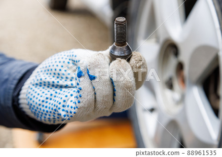 mechanic hand in fabric glove holding car wheel bolt mechanic hand in fabric glove holding car wheel bolt 88961535
