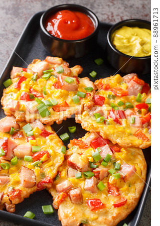 Vegetable pancakes with ham served with sauce close-up on a plate. vertical Vegetable pancakes with ham served with sauce close-up on a plate. vertical 88961713