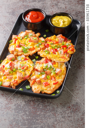 Fritters with ham, corn, peppers and green onions close-up on a plate. vertical 88961738