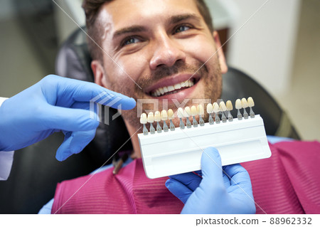 Smiley young man showing teeth to his dentist 88962332
