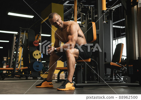 Handsome and muscular bodybuilder in a gym during workout 88962500