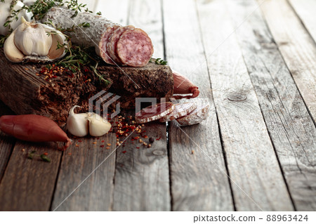 Dry-cured sausage on a old wooden table. 88963424