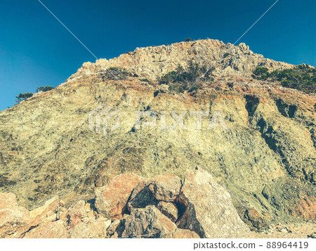 mountain on the sea. high, sandy cliff with stones at the resort. rock for climbing and mountaineering. rock texture mountain on the sea. high, sandy cliff with stones at the resort. rock for climbing and mountaineering. rock texture 88964419