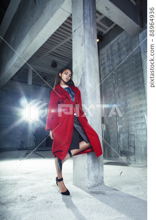 young pretty african american woman in luxury red coat posing fashionable on empty parking building, lifestyle rich people concept 88964936
