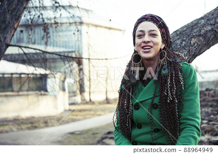 young adorable pretty girl with pigtails hairstyle smiling outside among trees 88964949