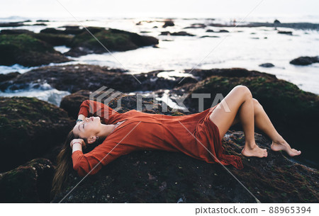 Unrecognizable woman lying on stone steps 88965394