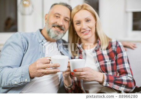 Happy family drinking tea while resting together on couch 88966280