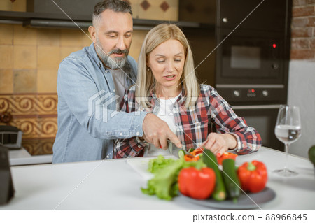 Mature loving couple cooking and using tablet on kitchen 88966845