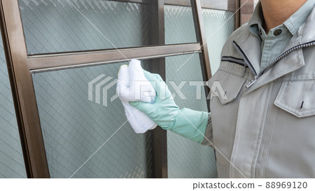 Image of a worker cleaning a screen door Image of a worker cleaning a screen door 88969120