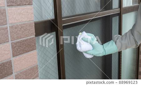Image of a worker cleaning a screen door 88969123