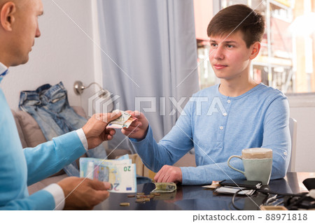 Father giving cash his son 88971818