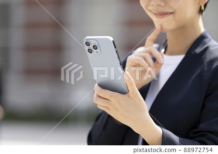 The hand of a business woman with a smartphone The hand of a business woman with a smartphone 88972754