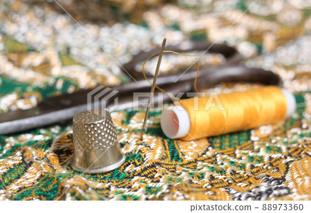 Golden Thread and Thimble on Vintage Fabric From The Middle East Golden Thread and Thimble on Vintage Fabric From The Middle East 88973360