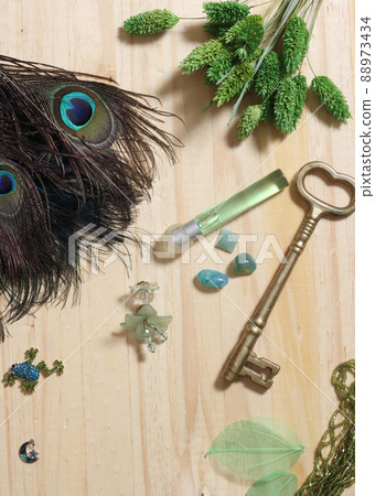 Peacock Feathers With Green Beads and Green and Copper Butterfly Broach on Wooden Background Peacock Feathers With Green Beads and Green and Copper Butterfly Broach on Wooden Background 88973434