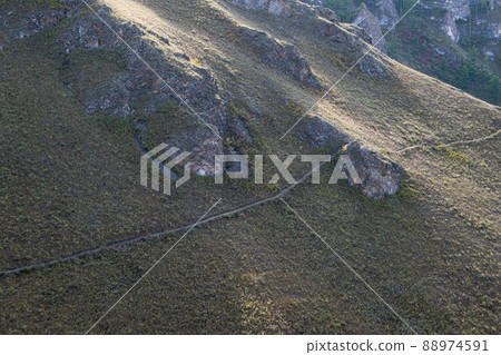 Hillside is crossed by hiking trail. Travel in mountains. Cross country running. Granite stones and cliffs protrude on slope. Hillside is crossed by hiking trail. Travel in mountains. Cross country running. Granite stones and cliffs protrude on slope. 88974591