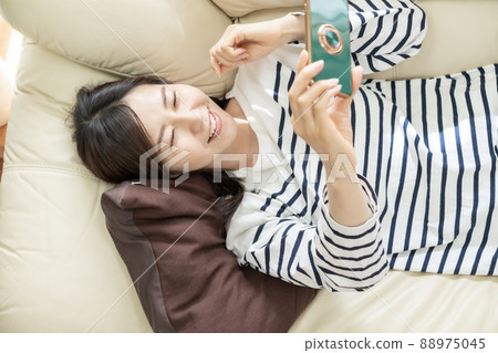 家庭主婦在智能手機上觀看視頻分發 88975045
