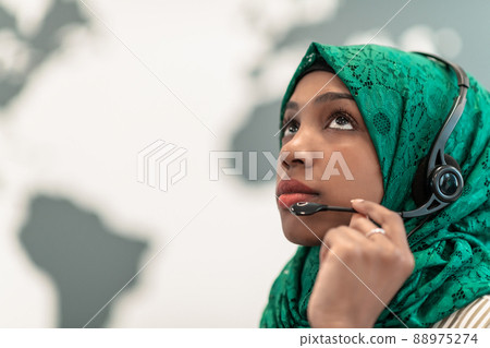 Muslim female with green hijab scarf customer representative business woman with phone headset helping and supporting online with customer in modern call centre 88975274