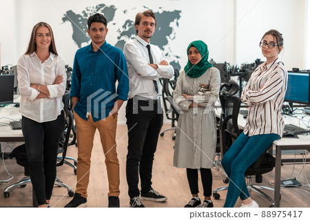 Portrait of young excited multiethnics business team of software developers standing and looking at camera at modern startup office Portrait of young excited multiethnics business team of software developers standing and looking at camera at modern startup office 88975417