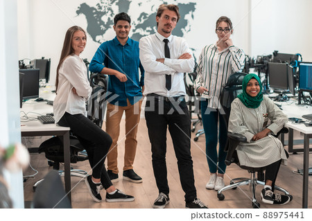 Portrait of young excited multiethnics business team of software developers standing and looking at camera at modern startup office 88975441