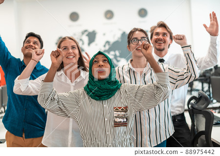 Portrait of young excited multiethnics business team of software developers standing and looking at camera at modern startup office Portrait of young excited multiethnics business team of software developers standing and looking at camera at modern startup office 88975442
