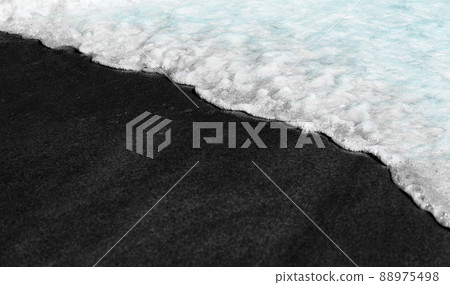 Black beach background waves black and white on volcanic sand texture washed over by water ocean wave tide. Serene idyllic ocean travel vacation concept banner Black beach background waves black and white on volcanic sand texture washed over by water ocean wave tide. Serene idyllic ocean travel vacation concept banner 88975498