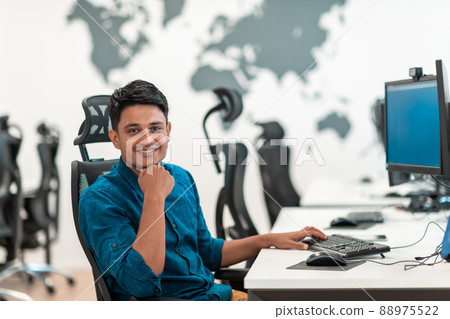 Casual business man working on desktop computer in modern open plan startup office interior. Selective focus  88975522