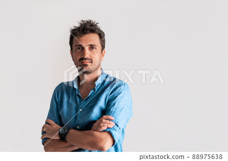 Formal business male portrait. A confident successful casual businessman or manager stands in front of a white background, arms crossed, looking directly at the camera and smiling friendly. High Formal business male portrait. A confident successful casual businessman or manager stands in front of a white background, arms crossed, looking directly at the camera and smiling friendly. High 88975638