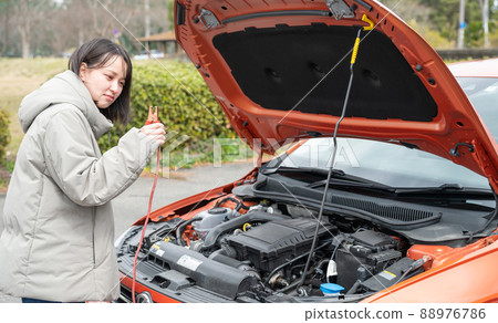 一個臉色難看的年輕女人解決汽車問題 88976786