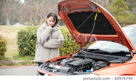A young woman with a face in trouble with a car A young woman with a face in trouble with a car 88976794