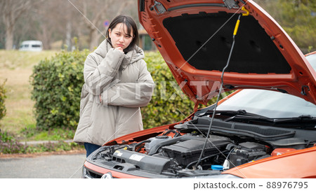A young woman with a face in trouble with a car A young woman with a face in trouble with a car 88976795