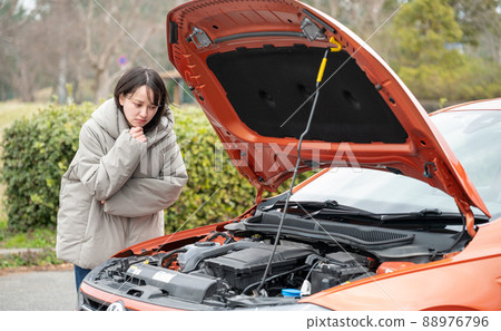 A young woman with a face in trouble with a car A young woman with a face in trouble with a car 88976796