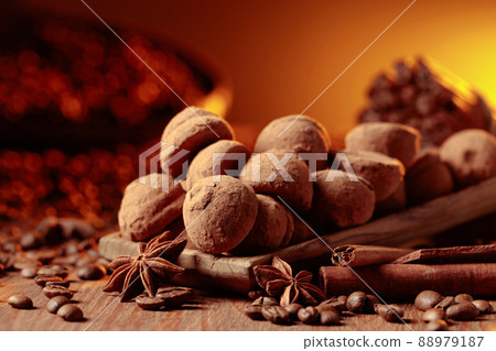 Chocolate truffles with cinnamon, anise, and coffee beans on a wooden table. Chocolate truffles with cinnamon, anise, and coffee beans on a wooden table. 88979187