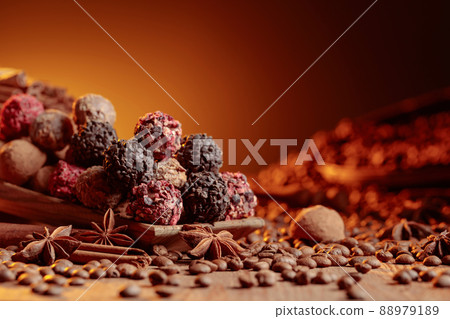 Chocolate truffles with cinnamon, anise, and coffee beans on a wooden table. 88979189