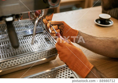 Male hands repairing coffee machine with screwdriver Male hands repairing coffee machine with screwdriver 88980712