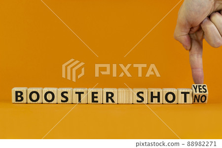 Covid-19 booster vaccine shot yes or no symbol. Doctor turns cubes and changes words booster shot no to booster shot yes. Beautiful orange background copy space. Covid-19 booster vaccine shot concept. Covid-19 booster vaccine shot yes or no symbol. Doctor turns cubes and changes words booster shot no to booster shot yes. Beautiful orange background copy space. Covid-19 booster vaccine shot concept. 88982271