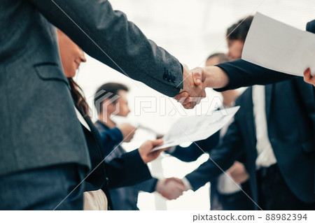 group of employees shaking hands at an office meeting. group of employees shaking hands at an office meeting. 88982394