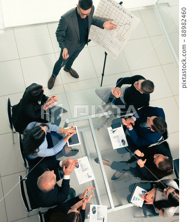 top view. the Manager explains the new strategy to the working group. top view. the Manager explains the new strategy to the working group. 88982460