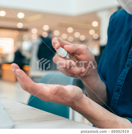 spray with antiseptic in the hands of a young man 88982919