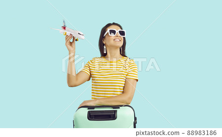Happy woman traveler with suitcase ready for vacation 88983186