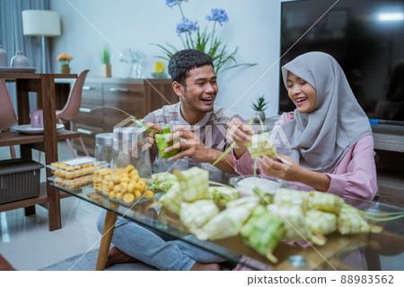 muslim couple asian making ketupat rice cake at home using palm leaf muslim couple asian making ketupat rice cake at home using palm leaf 88983562