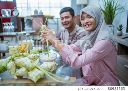muslim couple making ketupat for idul fitri traditional delicacy muslim couple making ketupat for idul fitri traditional delicacy 88983565