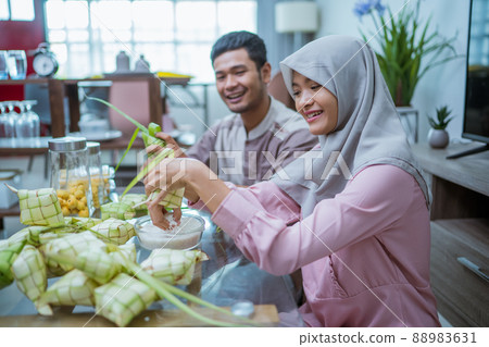 muslim couple making ketupat for idul fitri traditional delicacy muslim couple making ketupat for idul fitri traditional delicacy 88983631