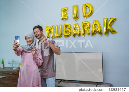 family taking selfie with eid mubarak decoration 88983657