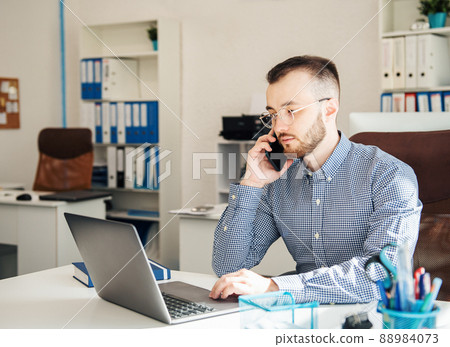 Businessman working on his laptop in an office Businessman working on his laptop in an office 88984073