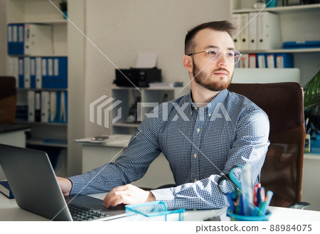 Businessman working on his laptop in an office 88984075