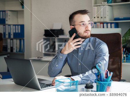 Businessman working on his laptop in an office Businessman working on his laptop in an office 88984076