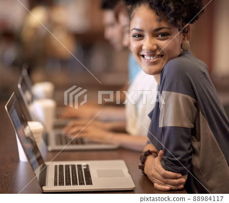 Working towards a bright future. A group of students using a laptop to complete a group assignment. 88984117