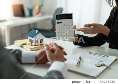 Real estate agent showing financial rate home loan for sign agreement customer the contract legally, Home sales and home insurance concept. 88984139