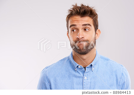 Uhhhmm.... A studio shot of a handsome man making a face. 88984413