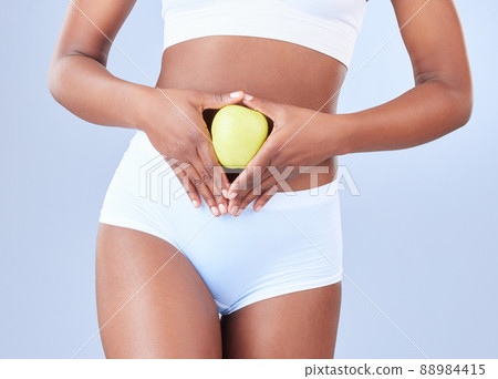 Your body deserves to be taken care of. Shot of an unrecognisable woman holding an apple over her stomach. 88984415